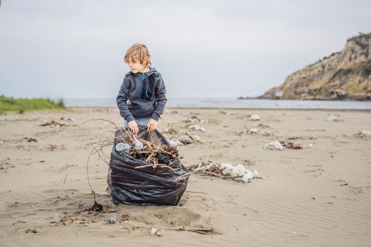 Volunteers cleaning beach from plastic. Boys walking on the beach and picking up plastic bottles trash and putting into plastic bag for recycle.
