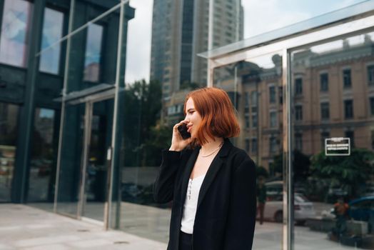A beautiful redhead business woman on the phone at work