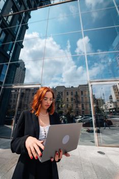 Smiling female looking at her laptop outdoors, modern lifestyle, connection, business, coffee break, communication, web chat, social media, video conference concept.