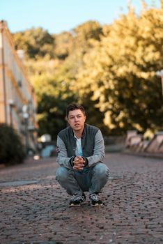 Picture of serious young man walking on the street and looking at camera.