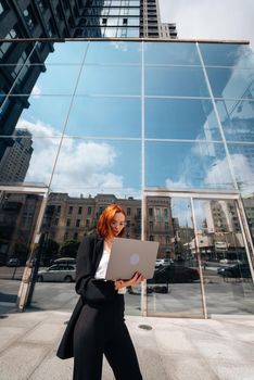 Smiling female looking at her laptop outdoors, modern lifestyle, connection, business, coffee break, communication, web chat, social media, video conference concept.