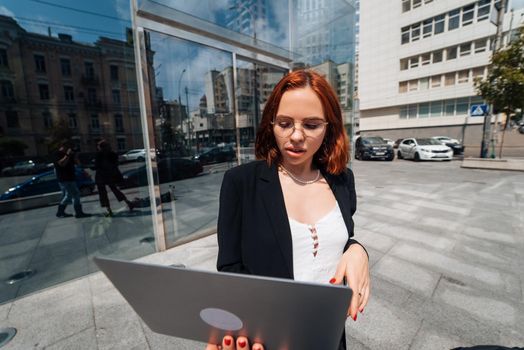 Smiling female looking at her laptop outdoors, modern lifestyle, connection, business, coffee break, communication, web chat, social media, video conference concept.