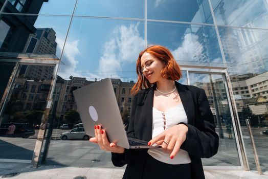Smiling female looking at her laptop outdoors, modern lifestyle, connection, business, coffee break, communication, web chat, social media, video conference concept.