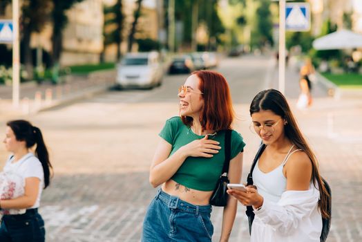 Two tourist friends consulting an online guide on a smart phone