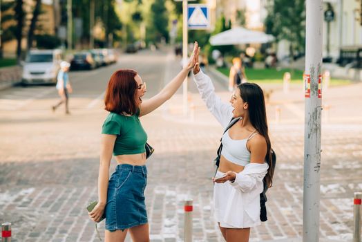 Two University students high five to teach others after successful work together