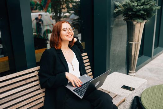 Photo portrait of gorgeous attractive woman working on laptop typing sitting in cafe drinking coffee
