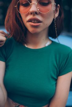 Young woman in glasses posing near car