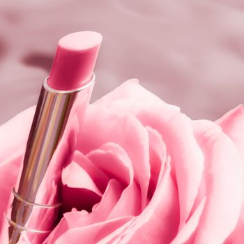 Cosmetic branding, luxe and fashion concept - Pink lipstick and rose flower on liquid background, waterproof glamour make-up and lip gloss cosmetics product for luxury beauty brand holiday design