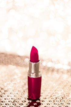 Cosmetic branding, sale and glamour concept - Maroon lipstick on golden Christmas, New Years and Valentines Day holiday glitter background, make-up and cosmetics product for luxury beauty brand