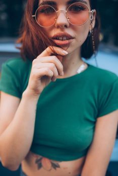 Young woman in glasses posing near car