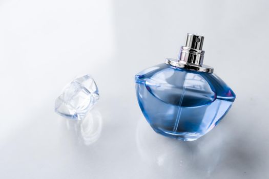Perfumery, spa and branding concept - Blue perfume bottle on glossy background, sweet floral scent, glamour fragrance and eau de parfum as holiday gift and luxury beauty cosmetics brand design