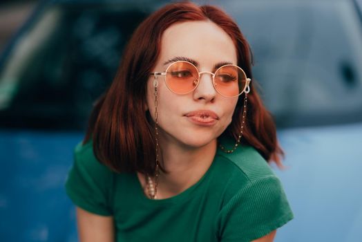 Young woman in glasses posing near car