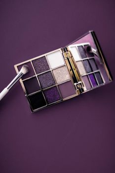 Cosmetic branding, mua and girly concept - Eyeshadow palette and make-up brush on purple background, eye shadows cosmetics product as luxury beauty brand promotion and holiday fashion blog design