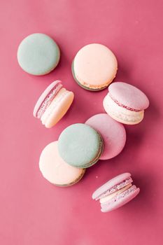 Pastry, bakery and branding concept - French macaroons on pastel pink background, parisian chic cafe dessert, sweet food and cake macaron for luxury confectionery brand, holiday backdrop design