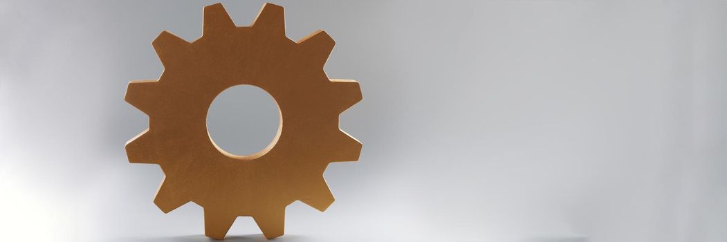 Close-up of large wooden gear on grey background, single mechanism for integrated development. Part of large complex system. Think process, idea concept