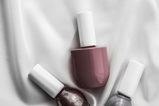 Cosmetic branding, salon and glamour concept - Nail polish bottles on silk background, french manicure products and nailpolish make-up cosmetics for luxury beauty brand and holiday flatlay art design