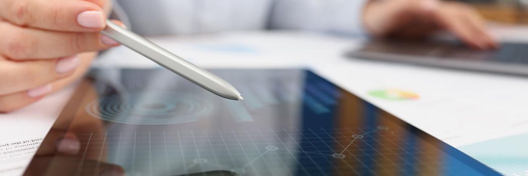 Close-up of female working on tablet with diagrams and charts on device screen. Business, strategy, statistics, report, development, stock market concept