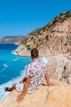 Kaputas beach Lycia coast Turkey Kaputas Beach, young men on vacation looking out over the Mediterranean Sea, Kas, Turkey.