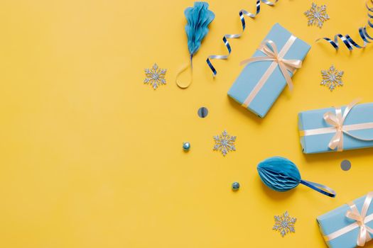 Christmas flat lay composition from gifts, paper balls and tinsel top view. Ukrainian yellow blue colors. Copy space.