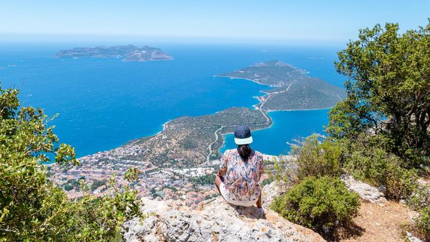 Kas turkey Asian women hiking up the mountain looking out over the ocean, Panoramic view from the mountain over the Kas Rivera, hiking up Lycian trail mountain of Kas Turkey.