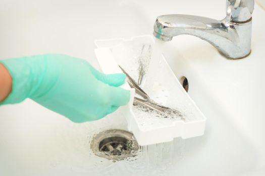 Hand in glove cleans the tweezers with water in-tray. Cleaning systems for tweezers