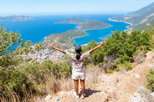 Kas turkey Asian women hiking up the mountain looking out over the ocean, Panoramic view from the mountain over the Kas Rivera, hiking up Lycian trail mountain of Kas Turkey.