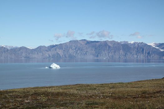 Stranded iceberg and ice near evening in arctic landscape, near Pond Inlet, Nunavut, Canada