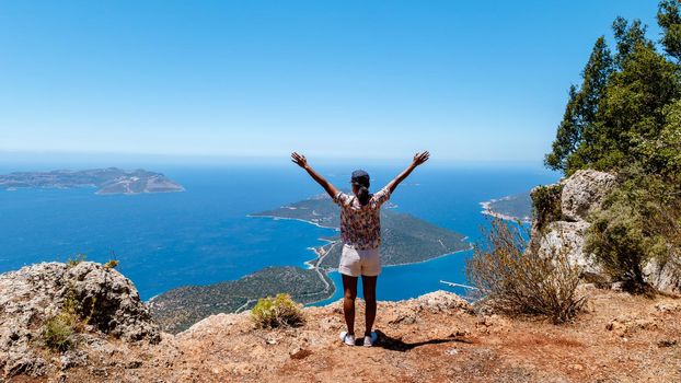 Kas turkey Asian women hiking up the mountain looking out over the ocean, Panoramic view from the mountain over the Kas Rivera, hiking up Lycian trail mountain of Kas Turkey.