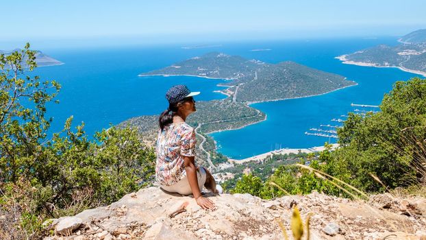 Kas turkey Asian women hiking up the mountain looking out over the ocean, Panoramic view from the mountain over the Kas Rivera, hiking up Lycian trail mountain of Kas Turkey.