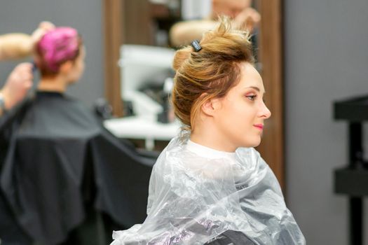Beautiful young blonde caucasian woman in the modern hair salon