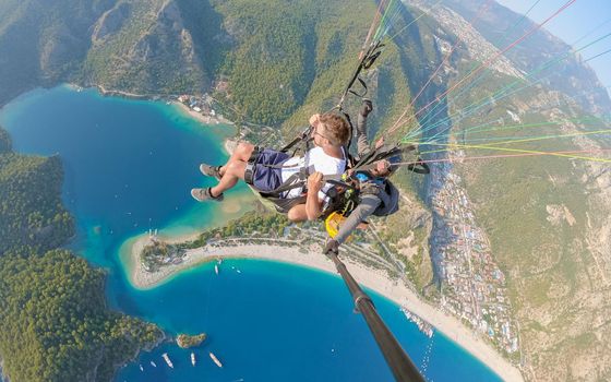 Paragliding in Fethiye, Turkey Paraglider flying above Oludeniz beach in Fethiye Turkey during sunset.