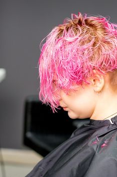 Beautiful young pink haired caucasian woman in the modern hair salon