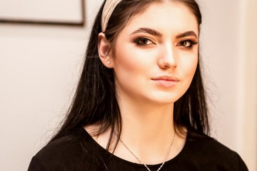 The fashionable young woman. Portrait of the beautiful female model with long hair and makeup. Beauty young caucasian woman with a hoop on her head