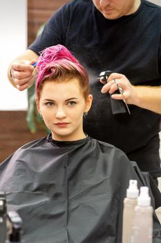 Beautiful young pink haired caucasian woman in the modern hair salon