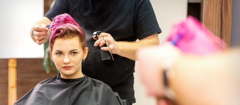 Beautiful young pink haired caucasian woman in the modern hair salon