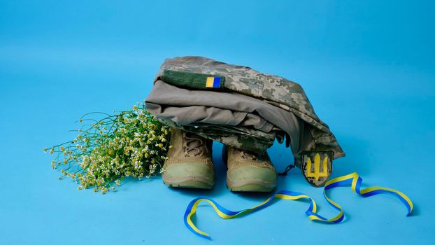 Military uniform of a Ukrainian soldier of the Armed Forces of Ukraine 2022 on an isolated blue background in a close-up studio in the war with Russia. Clothes of a true hero