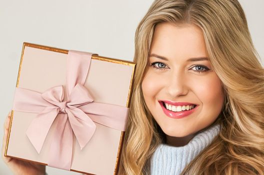 Winter holidays, present and Merry Christmas concept, happy woman smiling and holding wrapped gift box, close-up portrait