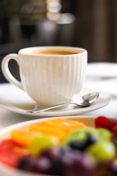 Breakfast and luxury, cup of coffee with milk and fruit platter on the served table for hospitality and gastronomy branding