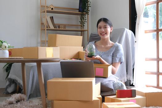 Startup small business entrepreneur SME, asian woman packing cloth in box. Portrait young Asian small business owner home office, online sell marketing delivery, SME e-commerce telemarketing concept.