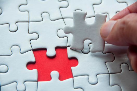 White jigsaw puzzle on red cover background with customizable space for text or idea. Copy space and puzzle concept.