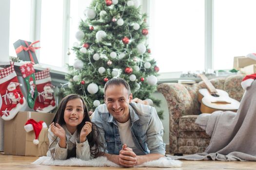 father and daughter near the Christmas tree.