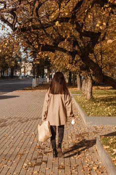 A stylish brunette woman walks around the autumn city. The season is autumn.