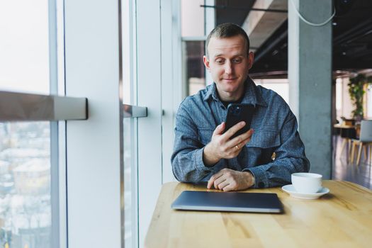 Excited young man in suit using mobile phone with funny expression, excited business man looking at his smartphone, reading good news via email, emotional lifestyle concept.