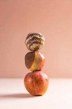 Apple with mold and fresh apple on beige background - mold growth and food spoilage concept