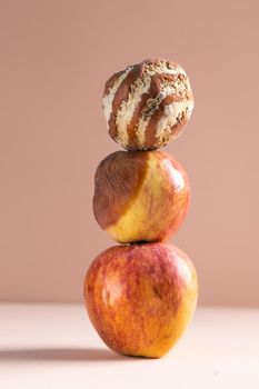 Apple with mold and fresh apple on beige background - mold growth and food spoilage concept