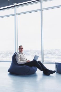 Young smart male businessman is sitting in the office and working on a project related to public cyber technology. Businessmen with laptop trying to meet deadlines in external marketing.