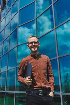 Cheerful businessman, formally dressed, pleased with received good news about contract details, sitting on office terrace with laptop, successful male entrepreneur