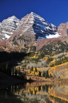 maroon bells mountain with snow and yellow aspen tree from colorado