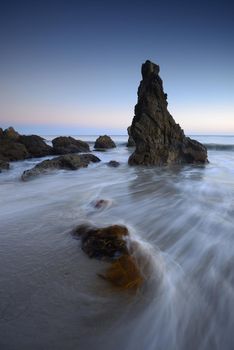 rock sea stack at a beach near malibu