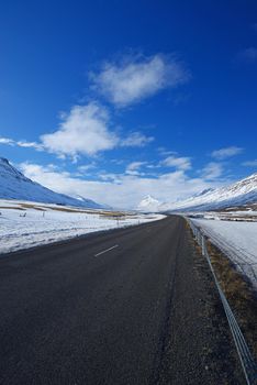 iceland road in winter surrounded by snow mountains